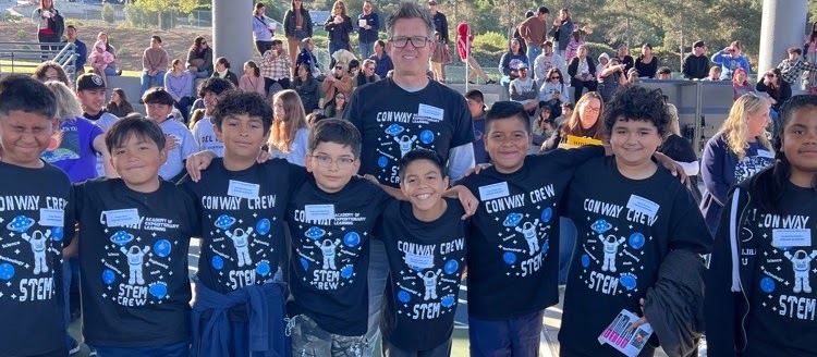 Conway Crew STEM students celebrating together in matching t-shirts at a community event