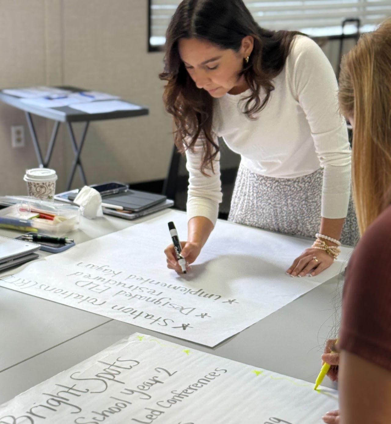 A Design39Campus educator writing notes on large paper sheets during a collaboration session